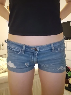Low waist shorts från Hollister - Snygga låg midja blåa jeansshorts från Hollister.Klassisk vintage design med dekorativa sömmar på bakfickorna och loggan där bak Perfekta för varma dagar och enkel att matcha med allt. Dem är i storlek 34 eller W25. Pris går att diskutera 🫶