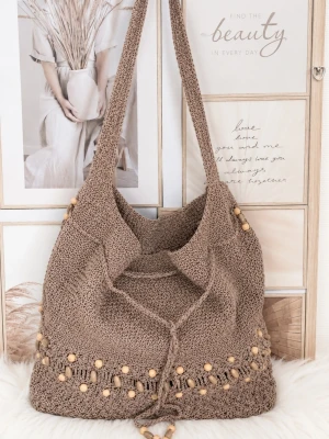 Beige virkad bohoväska - Snygg beige shoppingväska i stickat material med dekorativa träpärlor längs nederkanten. Väskan har en rymlig form och långa axelband, perfekt för att bära med sig allt man behöver. Bohemisk och trendig design som passar till många outfits.
