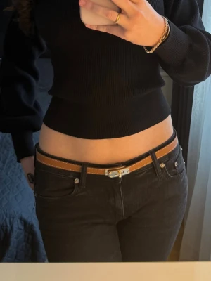 Brunt skärp med silverdetalj - Snyggt brunt skärp med silverfärgat spänne inspirerat av Her.mes. Skärpet är smalt och har en klassisk design som passar till jeans eller kjol. Tillverkat i skinn med stilrena sömmar längs kanterna. 