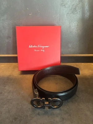 Ferragamo bälte - Skönt ferragamo bälte som passar till allt. Endast användt fåtal gånger så är som helt nytt. Alla påsar och box kommer med köp.