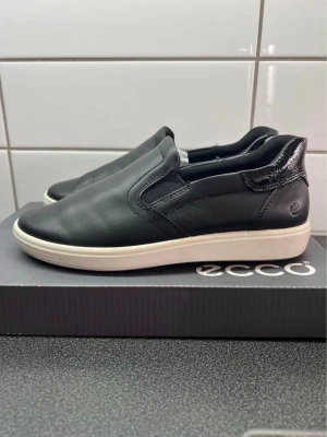 Ecco loafers i svart skinn stl 37, nya! - Säljer ett par stilrena svarta loafers från ECCO i mjukt skinn med vit sula och diskret logga på hälen. Aldrig använda, endast provade. Enkla att ta på och av.