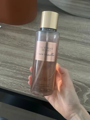 Victoria's Secret Bare Vanilla mist - Fräsch och söt doftmist från Victoria's Secret i doften Bare Vanilla. Flaskan är genomskinlig med guldigt lock och har en volym på 250 ml. Perfekt för dig som gillar varma, mjuka vaniljtoner. Snygg design som passar i väskan eller på sminkbordet.