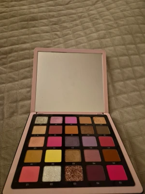 Norvina ögonskuggspalett ABH - Norvina Collection ögonskuggspalett från ABH med 25 färgstarka nyanser i både matta och skimrande finish. Paletten innehåller rosa, lila, gult, brunt, beige och glitter. Kommer i en ljusrosa förpackning med spegel och guldtext. 4-5 skuggor är swatchade. Testade. Fin palett i fint skick.