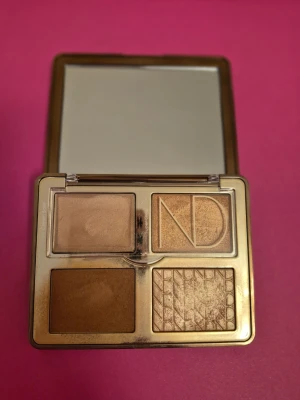 Natasha Denona Tan Bronze & Glow Palette - Snygg bronzerpalett från Natasha Denona med fyra olika nyanser i varma bruna och guldiga toner. Paletten har både matta och skimrande puder, perfekt för att skapa en solkysst look. Kommer i en lyxig guldfärgad ask med spegel. Testad någon gång eller två.  En fin palett. Fint skick.