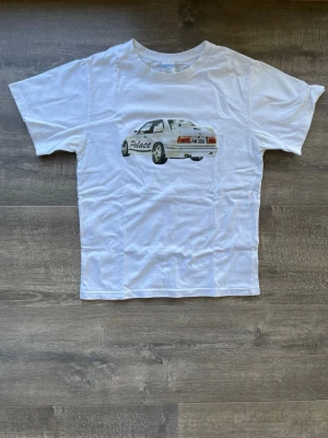 Vit Palace x asap rocky t-shirt  - Säljer en vit t-shirt från Palace x asap rocky med ett stort tryck av en sportbil och texten 'Palace' på framsidan. Tröjan är inte använd många gånger så den är i väldigt bra skick! Skriv vid frågor 