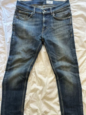 Riktigt feta tiger of Sweden jeans  - Snygga blå slim fit jeans från Nudie Jeans med klassisk femficksdesign och slitningar på låren. Jeansen har en något tvättad look och är tillverkade i denim med en skön passform. Perfekta för en avslappnad och trendig stil. Storlek 30:30 men skulle säga att de passar dig som är 165-172