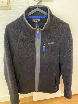 Svart fleece från Patagonia - Hej nu säljer jag en svart Patagonia fleece som är i väldigt bra skick! Fleecen är i storleken small och passar folk som är mellan 170-175. Den är väldigt skön och är sparsamt använd samt så passar den väldigt bra till lite kyligare sommarkvällar🙃