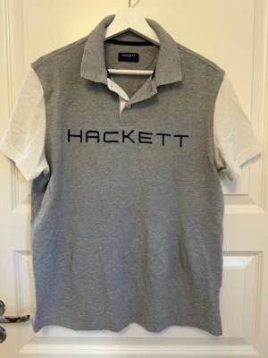 Hackett Piké - Hackett Golf. Ett par lösa trådar i loggan på bröstet
