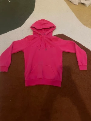 Rosa hoodie från Peak Performance - Säljer en snygg rosa hoodie från Peak Performance i storlek S (cirka 158). Hoodien har en klassisk känguruficka framtill, dragsko i huvan och ribbade muddar vid ärmar och nederkant. Den är lite trasig på snöret men annars väldigt fin. Perfekt för en chill och sportig stil. Skriv om du har några frågor.