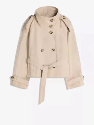Kort beige trenchcoat med bälte - Stilren kort trenchcoat i beige med dubbelknäppning, högt krage och bälte i midjan. Jackan har axelklaffar, dekorativa knappar och justerbara ärmslut. Perfekt för dig som gillar klassisk men modern look. Materialet ser ut att vara bomull eller bomullsblandning. Jackan är från Bershka och knappt använd, alltså inga defekter alls.