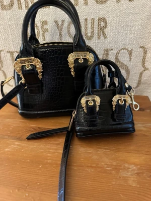 Versus Versace  - Snygg set av versus Versace väskor . Den lilla kan hängas på den stora , använt ett fåtal gånger köpt på Zalando 