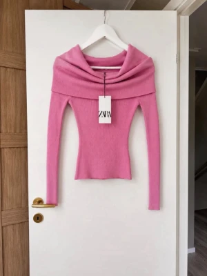 Rosa ribbad topp från Zara - Trendig rosa ribbad topp från Zara med bred offshoulder-krage och långa ärmar. Toppen har en croppad passform och är tillverkad i mjukt stretchigt material som sitter snyggt på kroppen. Storlek S med prislapp kvar 