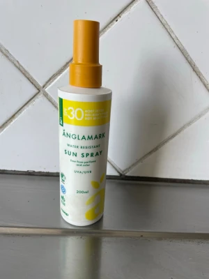 Änglamark Sun Spray SPF 30 200ml - Solskyddsspray från Änglamark med SPF 30. Vattenresistent formula, fri från parfym och färgämnen. Flaskan är vit med gula detaljer och spraymunstycke. Innehåller 200 ml och skyddar mot både UVA och UVB.