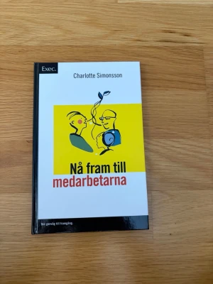 Nå fram till medarbetarna - Kurslitteratur av Charlotte Simonsson med hård pärm, vit och svart omslag med gul illustration. Boken handlar om kommunikation och ledarskap inom organisationer och ger praktiska råd för chefer och ledare. Perfekt för studier inom HR, kommunikation och management.