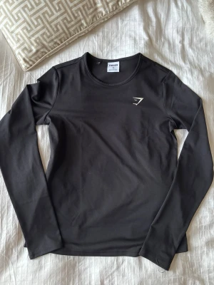 Svart långärmad gymshark träningströja - Nypris 250kr. Supersnygg tröja som knappt blivit använd, därav säljer jag den! 