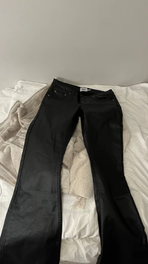 Svarta bootcut jeans från 157 - Säljer ett par svarta bootcut jeans från 157 med låg midja. Storlek S short lenght! Jeansen har klassisk femficksdesign och är tillverkade i ett glansigt material. Endast provade men dock ej prislapp kvar, köp jeansen o få me extra grejer (se bild 4-5!💗)