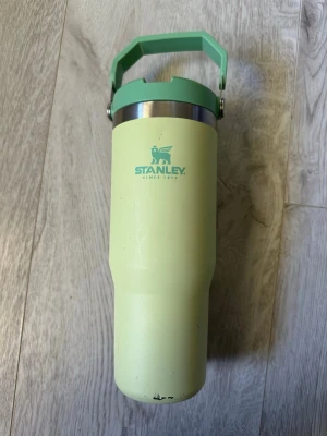 Stanley vattenflaska 887 ml grön tumbler  - Stanley vattenflaska i ljusgrön färg med mintgrönt handtag och lock. Tillverkad i rostfritt stål och plast, rymmer 887 ml. Perfekt för att hålla drycken kall 