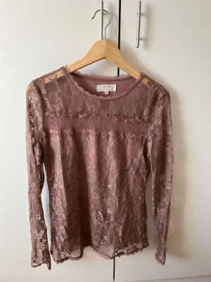Rosa spetsblus från Object - Säljer en rosa spetsblus med långärmad design och delvis genomskinligt spetsmaterial. Blusen har ett fint blommigt mönster och rund halsringning💕💕