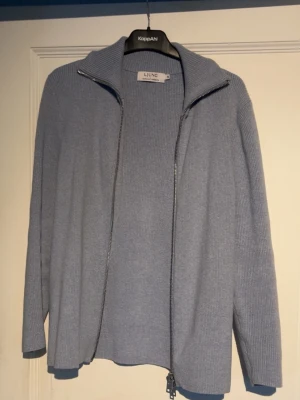 Ljusblå stickad kofta från Ljung - Ljusblå stickad kofta från Ljung med dragkedja framtill och hög krage. Tröjan är knappt använd och relativt nyköpt. Nypris ligger på typ 1200kr