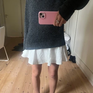 Vit kjol med broderade detaljer - Supersöt vit kort kjol med volang och broderade små blommor. Kjolen har en loose passform och är perfekt för varma dagar. Materialet är bomull och ger en fräsch och lätt känsla. Passar dig som gillar romantisk och feminin stil. Dock en liten fläk på framsidan men den syns knappt💕