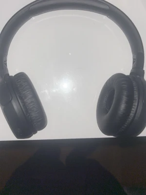 Svarta over-ear hörlurar från JBL - Säljer ett par snygga svarta over-ear hörlurar från JBL. De har mjuka, vadderade kåpor och en robust båge i plast och konstläder. Perfekta för att lyssna på musik eller poddar med riktigt bra ljud och komfort. Du kan byta storlek på dom så dem passar din huvudform 