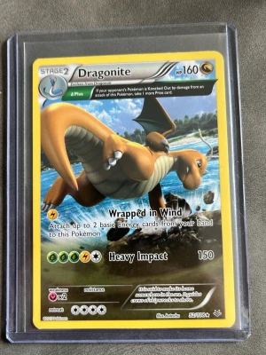 Dragonite Pokémonkort 52/108 - Säljer ett Dragonite Pokémonkort med nummer 52/108. Kortet har en gul ram och motiv av Dragonite som flyger över vatten. Kortet är i plastficka och har detaljer som HP 160, attacker Wrapped in Wind och Heavy Impact. Perfekt för samlare eller Pokémonfans.