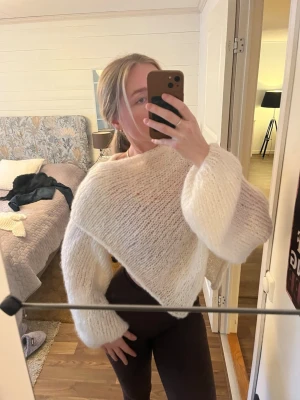 Vit stickad poncho bolero luva - Säljer en vit stickad bolero, ponch och luva med sjal, asymmetrisk passform. Tröjan är gjord i ett fluffigt garn som ger en mjuk och luftig känsla. Perfekt för dig som gillar trendiga och unika plagg med cool design. Kan även köpa en del för 250 kr/ del