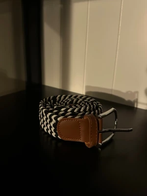 Flätat bälte svart vitt - Ett riktigt snyggt flätat bälte. Bältet är svart vitt och passar till det mesta. Skicket är otroligt bra då de endast är använt någon enstaka gång. Skriv vid frågor och kolla gärna in min profil för fler bälten och kläder!