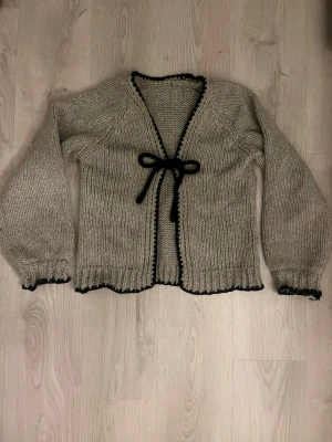 Grå stickad kofta med svart kant - Mysig grå stickad kofta. Pris kan alltid diskuteras 💕