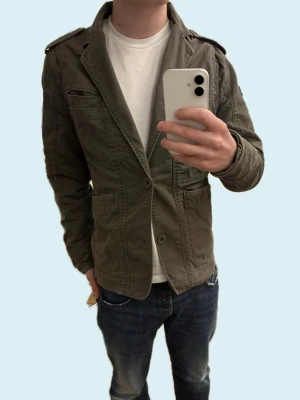 Olivgrön safari jacka från Jack and Jones  - Unik och riktigt snygg safari jacka. Riktigt skön och stilig till våren! Hör av er i DM vid fler frågor.