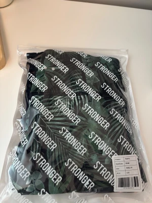 Stronger tights med grönt bladprint - Två stycken snygga tights från stronger. Ett par med grön design och en med svart. 2 för 500kr!