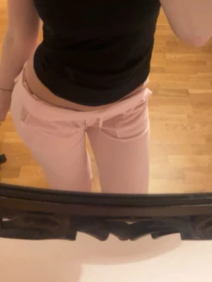 Ljusrosa mjukisbyxor med dragsko - Säljer ett par ljusrosa mjukisbyxor med dragsko i midjan och fickor framtill. Byxorna har en relaxed fit och är perfekta för chill dagar. Materialet ser mjukt och bekvämt ut, perfekt för att hänga hemma eller till vardagslooken.