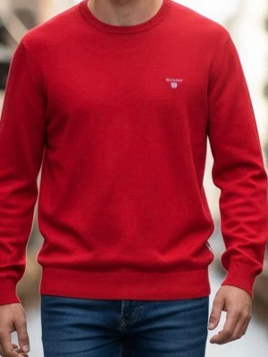 Röd stickad tröja från Gant - Snygg röd stickad tröja från Gant med rund halsringning och diskret logga broderad på bröstet. Tröjan har långa ärmar och ribbade muddar vid ärmslut och nederkant. Perfekt för dig som gillar klassisk och stilren design. (GT0008)