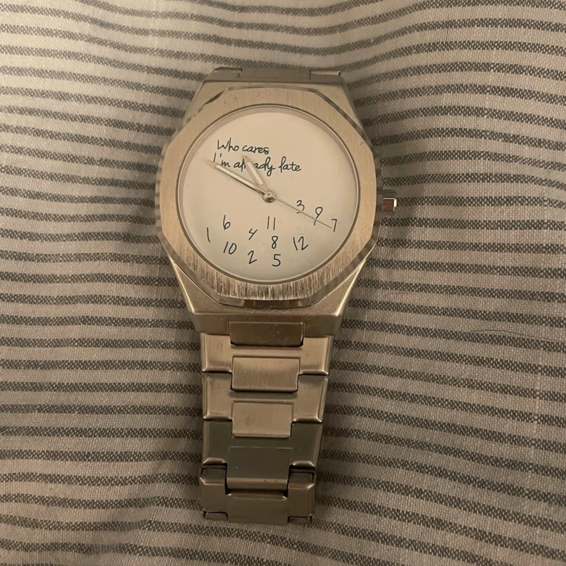 Silvrig klocka med textad urtavla