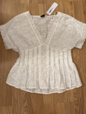 Vit spetsblus med v-ringning - Söt vit blus från Gina Tricot i spetsmaterial med blommigt mönster. Slutsåld online 