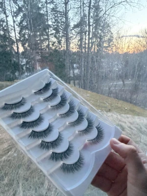 10-pack svarta lösögonfransar - Säljer ett 10-pack svarta lösögonfransar i plastförpackning. Fransarna är långa, täta och har en naturlig böjd form för extra volym. Perfekt för dig som vill ha en dramatisk look. Materialet är syntetiskt och fransarna är lätta att applicera med franslim.