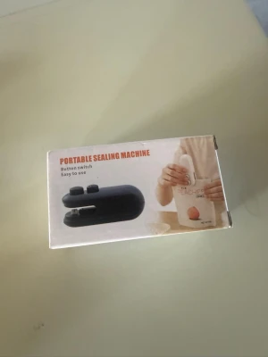 Portabel förslutningsmaskin  - Smidig portabel förslutningsmaskin i svart plast, perfekt för att snabbt och enkelt försluta påsar. Maskinen har knapp för enkel användning och laddas via USB. Passar bra i köket eller på resan när du vill hålla snacks och mat fräscha.