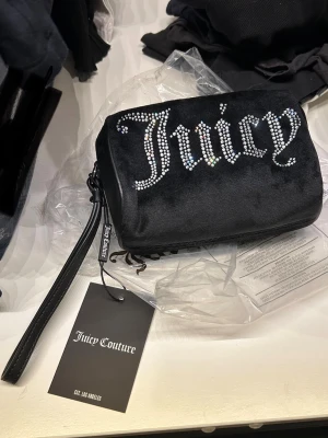 Juicy couture neccesär / väska med hängsmycke - Väska/ neccesär från juicy couture med detaljer och fickor på insidan. Tillhörande hängsmycke / nyckelring❤️ helt ny finns inte att köpa längre