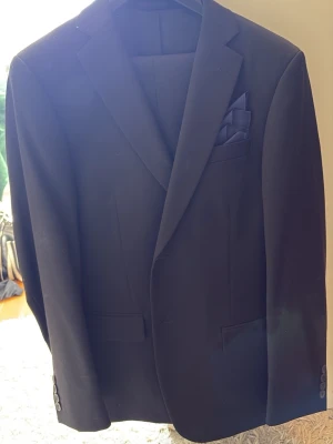 Svart klassisk kavaj med kostymbyxor  - Snygg svart kavaj med svarta kostymbyxor. Kavajen är en 50 short slim fit medans byxorna är storlek 32-33. Använd 1 gång. 