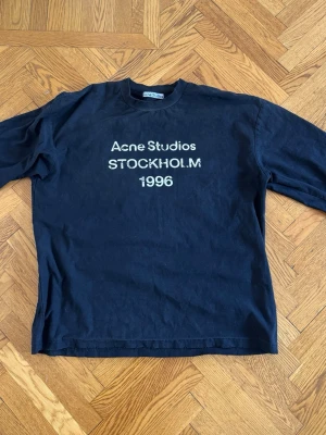 Acne Studios långärmad t-shirt svart - Acne Studios långärmad t-shirt för herr i storlek S. Tröjan är svart och är i lite tjockare t-shirt material. Modellen har rund halsringning och tryck med "Acne Studios Stockholm 1996" på bröstet. Inget kvitto, köpt second hand och kan därför inte garantera ÄKTHET. Skötselråds lappen har blivit avklippt av tidigare ägare.