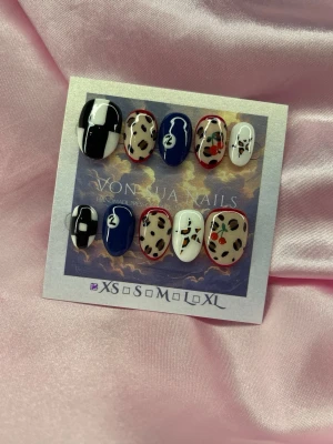 CherryE.X.E (XS);Short Oval  - Unika handgjorda press-on naglar i mixade designer: svartvita block, leopardmönster med röda detaljer, marinblå och vita naglar med handmålade motiv. Alla naglar har en glansig finish och är gjorda i XS: 14 mm, 11 mm, 11,5 mm, 10 mm, 8 mm  . Perfekt för dig som vill sticka ut med kreativa naglar.