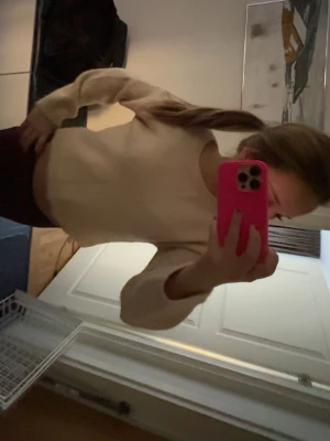 Ljus rosa stickad tröja med rund hals - Mysig ljus ljus rosa stickad tröja med rund hals och långa ärmar. Tröjan har en enkel, klassisk design och är lätt att matcha till olika outfits. Perfekt för kyligare dagar och ger en avslappnad men stilren look.