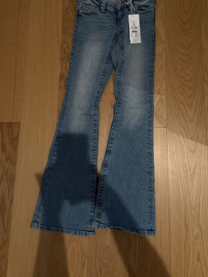 Ljusblåa bootcut jeans från Gina Tricot - Säljer ett par ljusblå bootcut jeans från Gina tricot med snygga broderade detaljer på bakfickan. Jeansen har klassisk femficksmodell och är tillverkade i stretchigt denimtyg för extra komfort. Aldrig blicit använda mer originala prislappar kvar😊