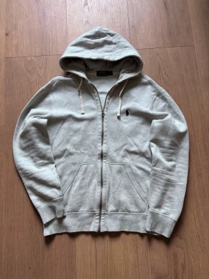 Grå hoodie från Polo Ralph Lauren - Tja! Säljer nu en riktigt schysst ljusgrå zip hoodie från Ralph Lauren! Storlek M, utan hål eller defekter. Vid frågor är det bara att höra av sig! 