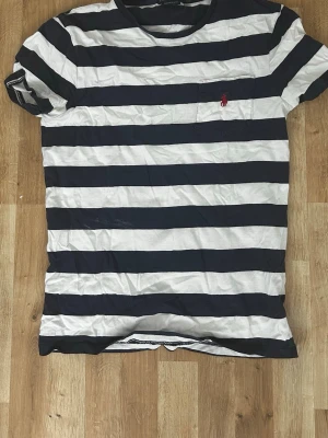 Ralph lauren tshirt - Säljer denna T-shirten från Ralph lauren. Väldigt stilig och nice att ha på sommaren speciellt. Den har en vitt fläck lite vid mitten delen av T-shirten men den går bort om man tvättar den engång. Skriv om ni är intresserade 