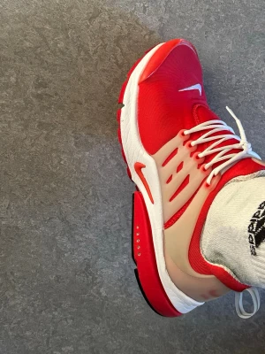 Nike Presto röda  - Säljer ett par Nike Presto sneakers i rött med vita detaljer och vit sula. Skorna har en mesh-överdel för bra andningsförmåga och plastdetaljer på sidorna för extra stöd. Klassisk Nike Swoosh på tå och sidor. Låga och riktigt sköna på foten.