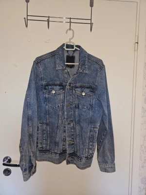  2St!! Klassisk blå och svart jeansjacka - Snygg blå jeansjacka i klassisk modell med raka linjer och två bröstfickor med knappar. Jackan har knäppning framtill och sidofickor. Perfekt för dig som gillar en tidlös streetstil och vill ha en jacka som funkar till det mesta. Båda för 299
