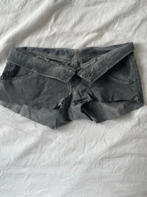 Grå jeansshorts  - Supercoola jeansshorts i ett ganska tunt jeanstyg. Coola detaljer på fickorna. De har fyra knappar framtill och är väldigt lågmidjade. Sparsamt använda. Stl XS. 💕