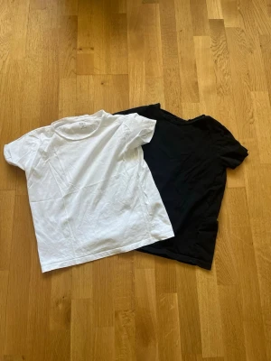 Svart och vit t-shirt från 157 - Två basic t-shirts från 157 i storlek XS, en svart och en vit. Båda är kortärmade och tillverkade i 100% bomull. Perfekta att matcha med jeans eller shorts för en clean och enkel stil.