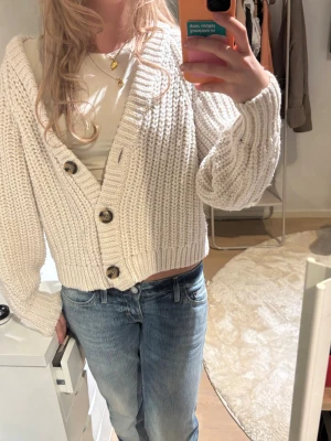 Beige stickad kofta med knappar - Kofta från H&M. Säljer då den inte kommer till använding. Perfekt över ett linne eller en T-shirt 